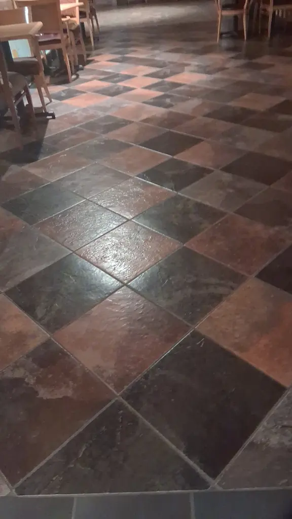 Checkerboard slate tile and grout cleaned in a commercial dining area