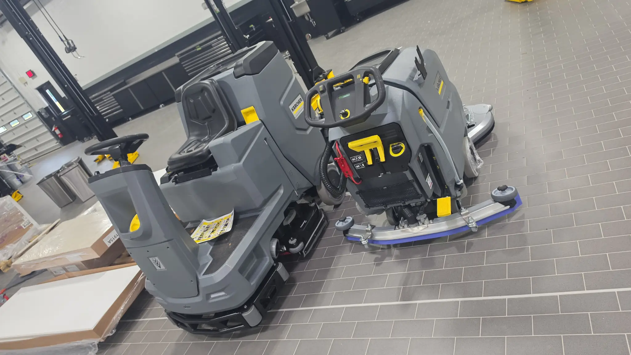 Ride-on floor scrubbers staged for an overnight commercial cleaning shift
